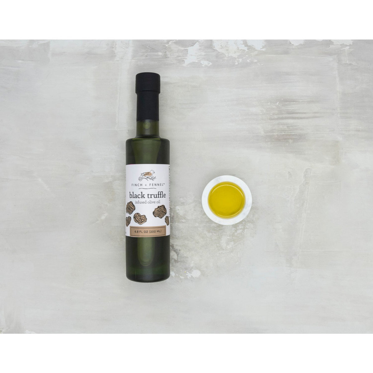 Bottle of black truffle infused olive oil with a dark label.