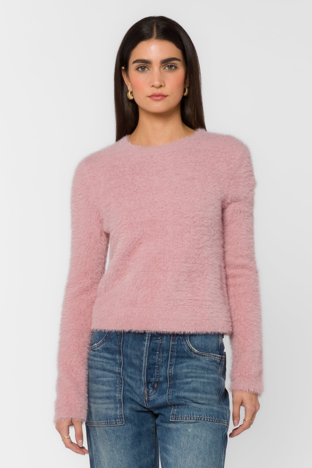 Woman wearing the Harmony Sweater, a pink plush eyelash knit crewneck with long sleeves.