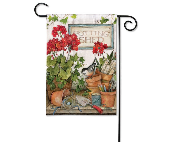 Garden flag with a watercolor illustration of red geraniums, a bird, and gardening tools.