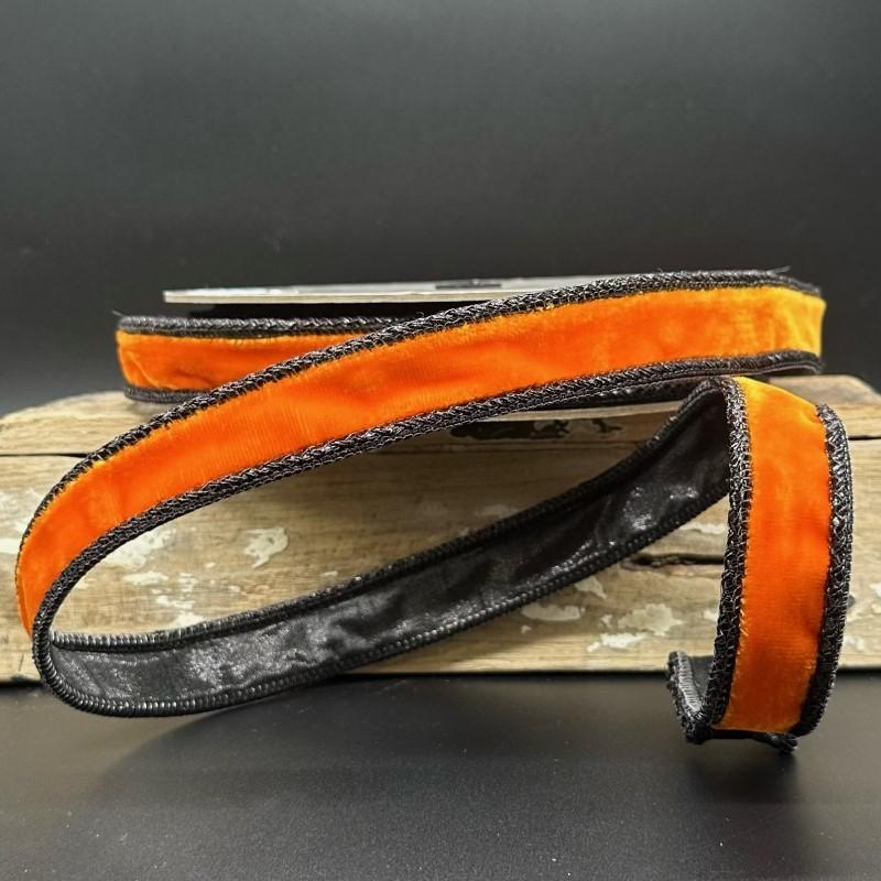 1 inch wide orange velvet ribbon with black braided edges on a wooden block.