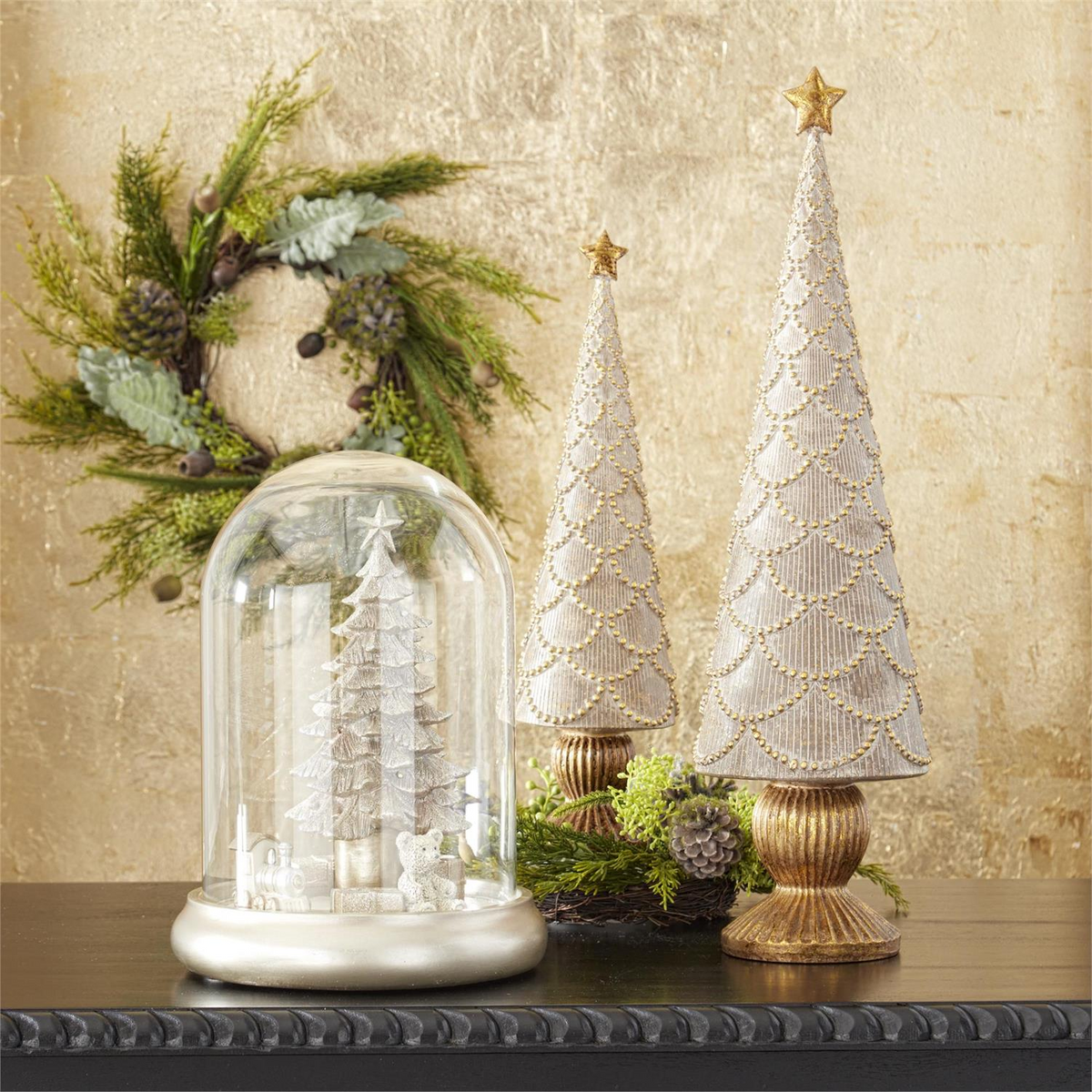 Tan resin tabletop trees with gold scalloped details and star toppers on a dark surface.