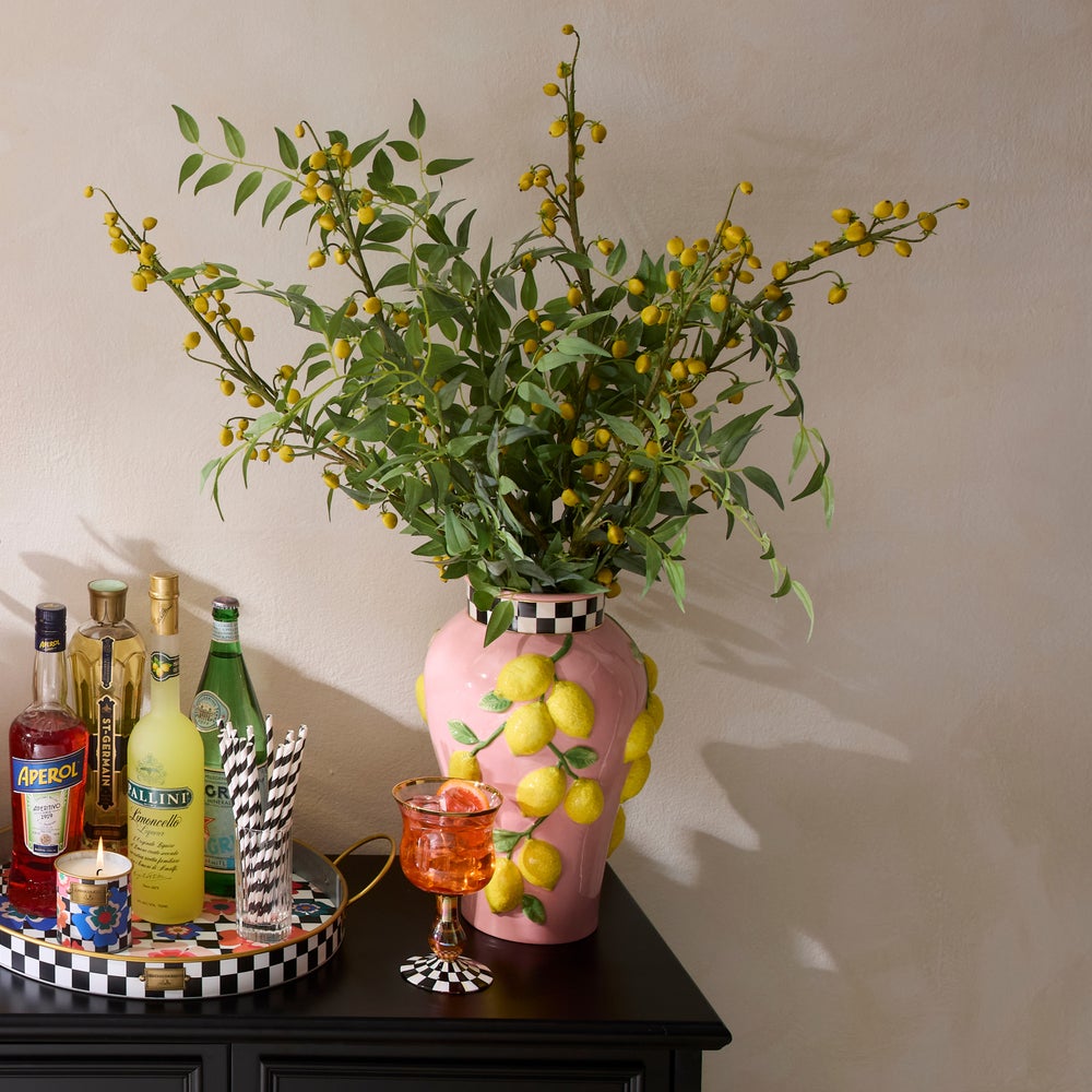 Pink ceramic Tutti Frutti Lemon Vase with 3D lemon accents and a checkered rim on a black table.