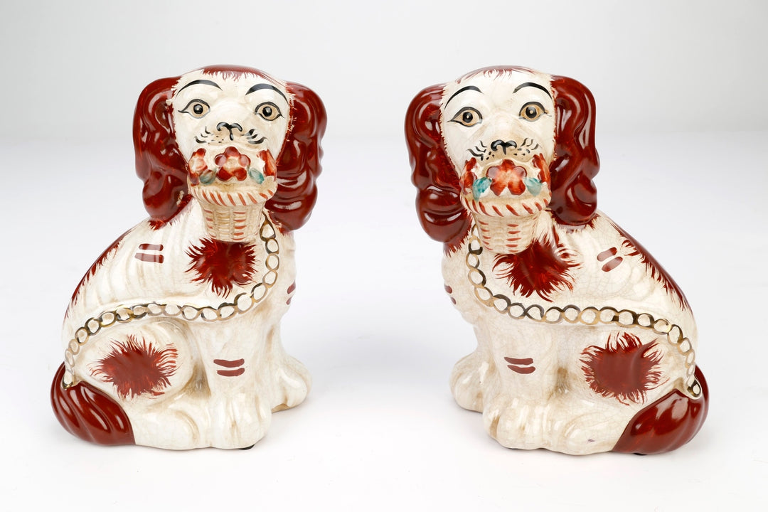 Pair of Staffordshire dog figurines in black with white floral baskets