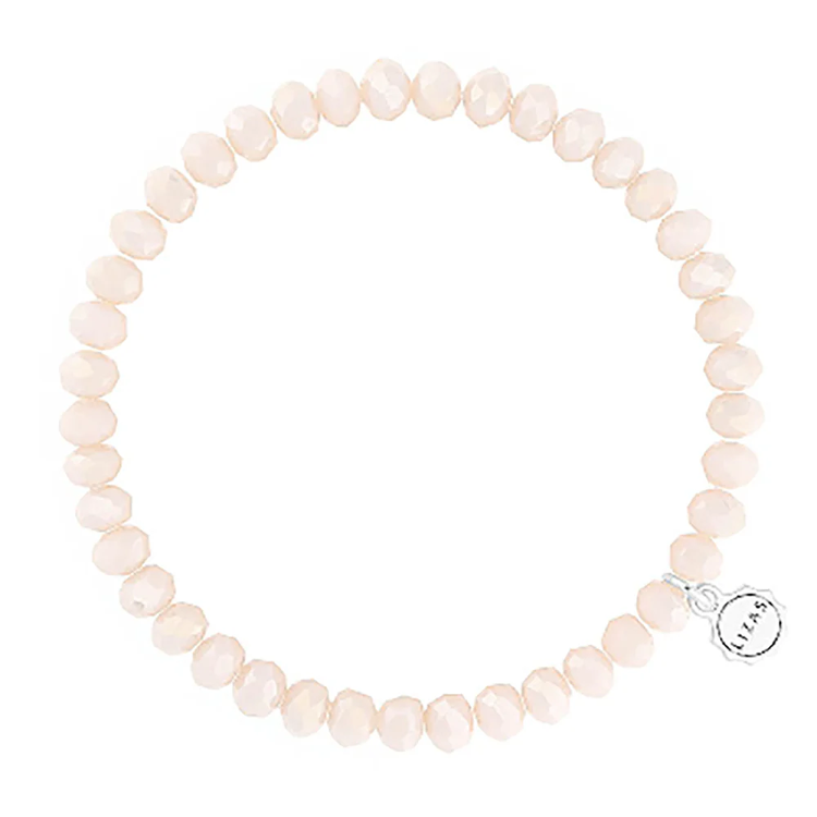 Lizas Quadro Big crystal stretch bracelet in light peach with a silver logo charm.