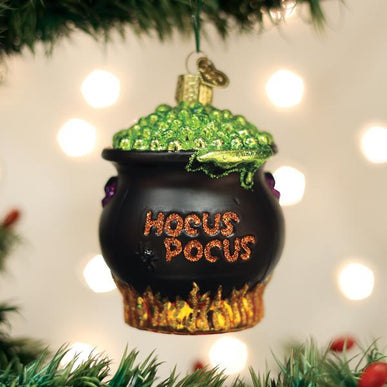 Black cauldron Halloween ornament with a witch figure inside.