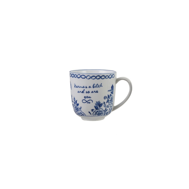 Blue and white stoneware mug with floral patterns and the text "Karma's a bitch and so are you".
