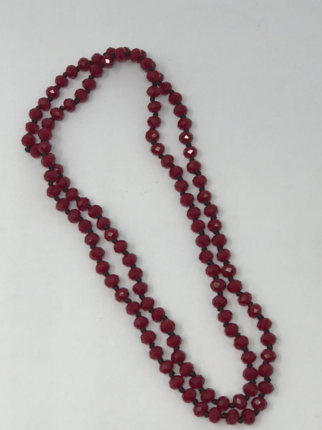 36-inch dark brown crystal beaded necklace with knotting between each bead.
