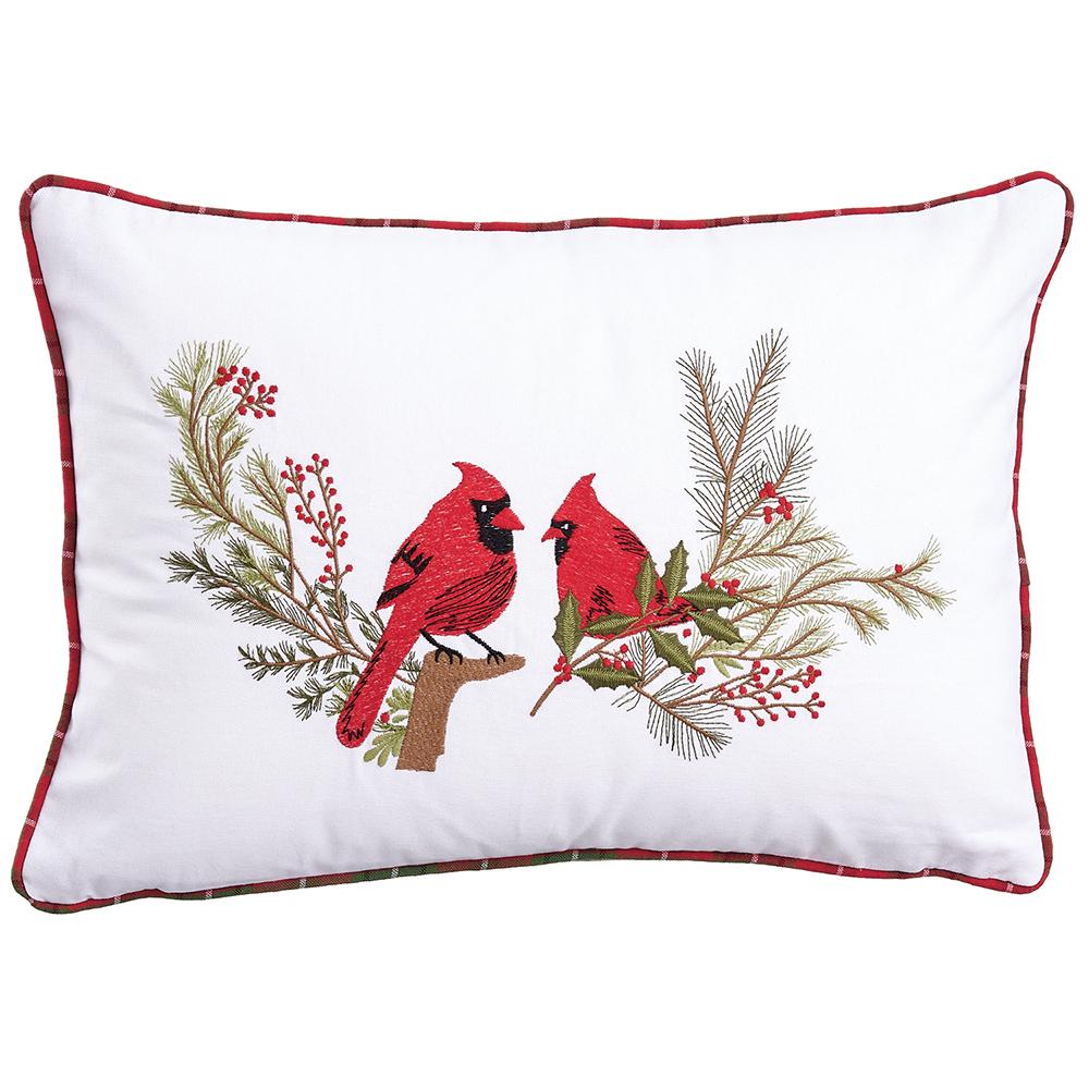 White rectangular pillow with embroidered red cardinals on pine branches and red piped edges.