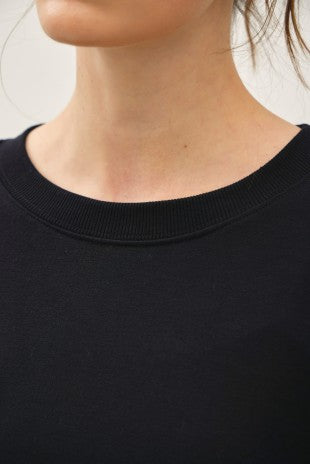 Close-up of a black Terry Brushed Sweatshirt featuring a ribbed crew neckline.