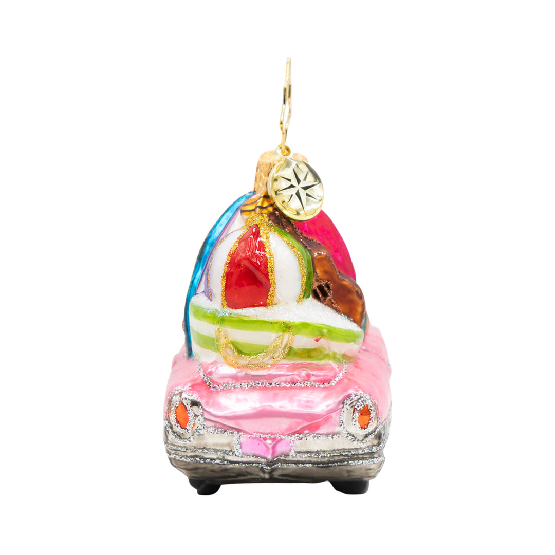 Pink convertible Christmas ornament with a surfboard and beach gear on top.