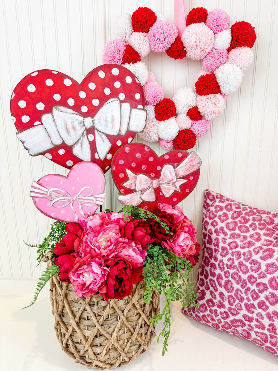 Stakeable wall hanging featuring a polka dot heart pattern in red on white fabric.