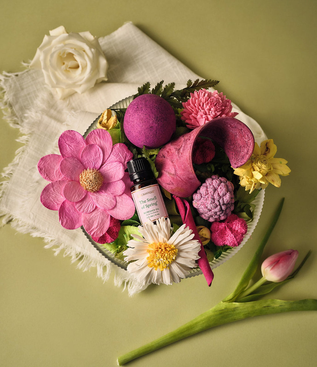 The Smell of Spring Refresher Oil bottle in a bowl of pink, white, and yellow potpourri flowers.
