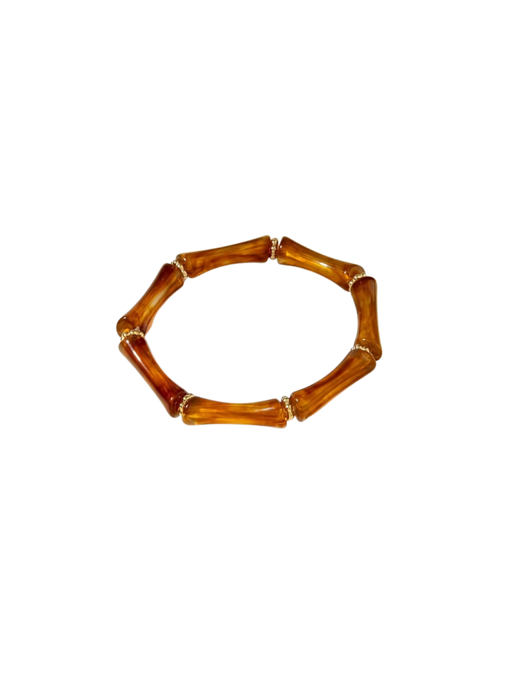 Amber-colored resin tube stretch bracelet with small gold-tone spacer beads.