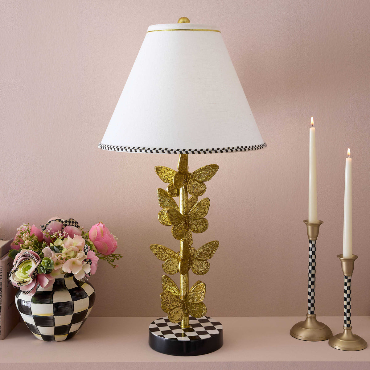 Flutter Table Lamp with a gold butterfly base and a white shade with a checkered border.