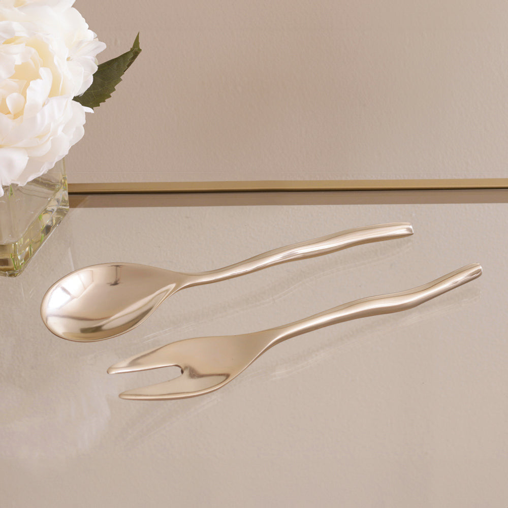Sierra Modern Maia small salad servers in a polished gold finish on a glass surface.