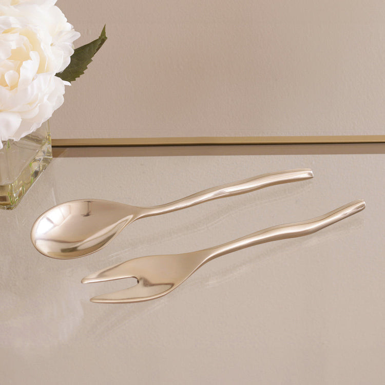 Sierra Modern Maia small salad servers in a polished gold finish on a glass surface.