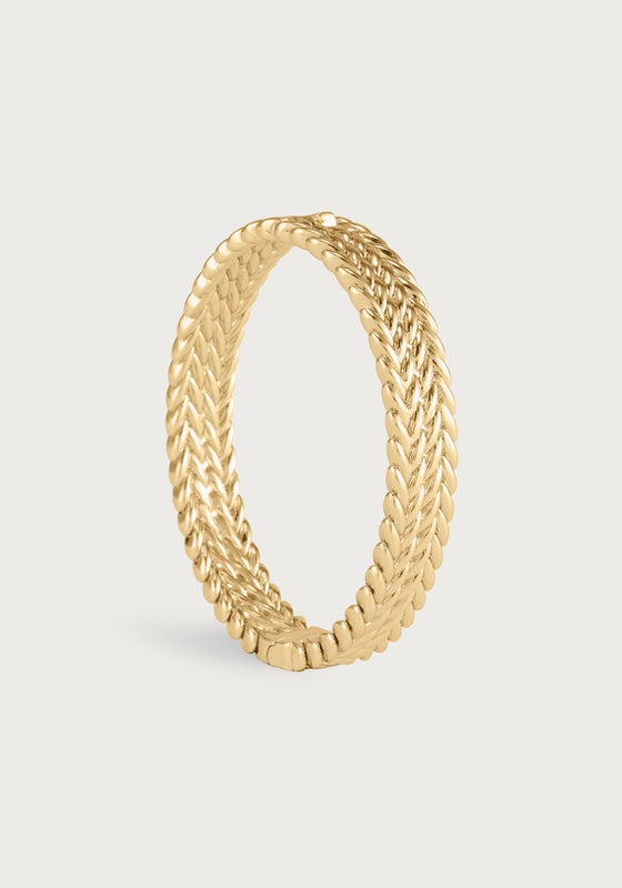 Thick gold-plated braided hinged bangle with a sculptural equestrian-inspired texture.