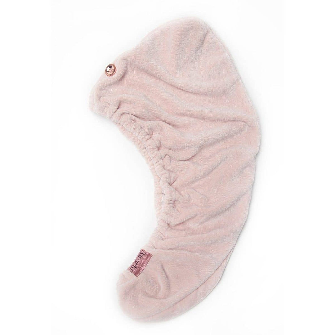 Blush-colored quick-dry hair towel made from organic cotton and bamboo with stretch elastic trim.
