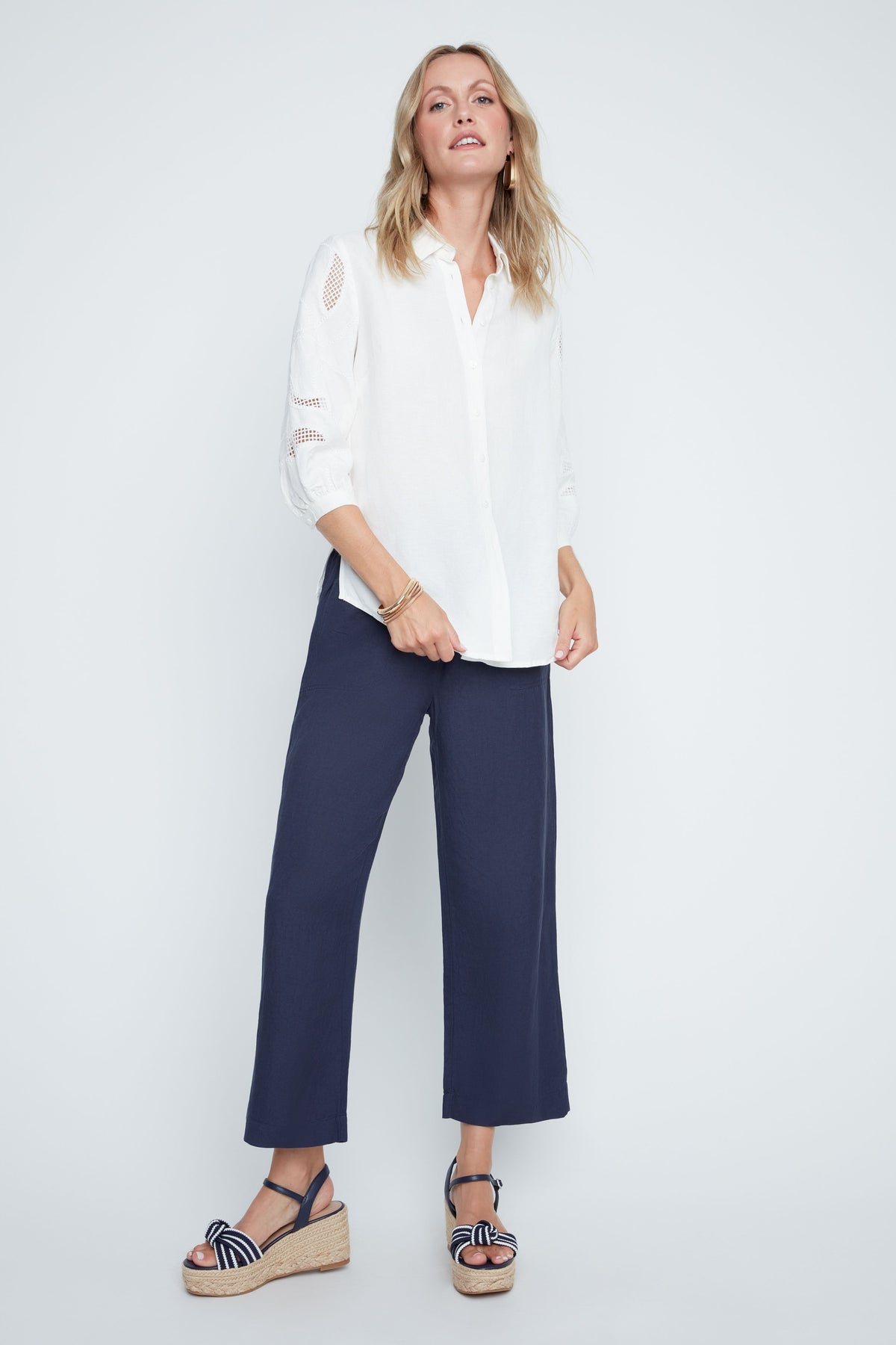 Hannah woven blouse in soft neutral tone with relaxed fit, button front, sheer sleeve panels, and subtle textured detailing.