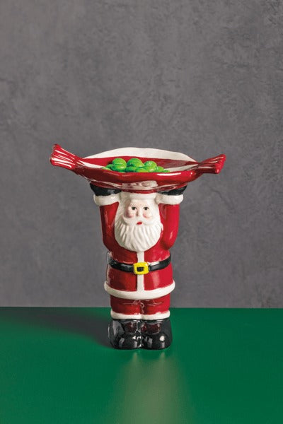 Ceramic Santa Claus figurine holding a red candy-shaped dish filled with green treats.