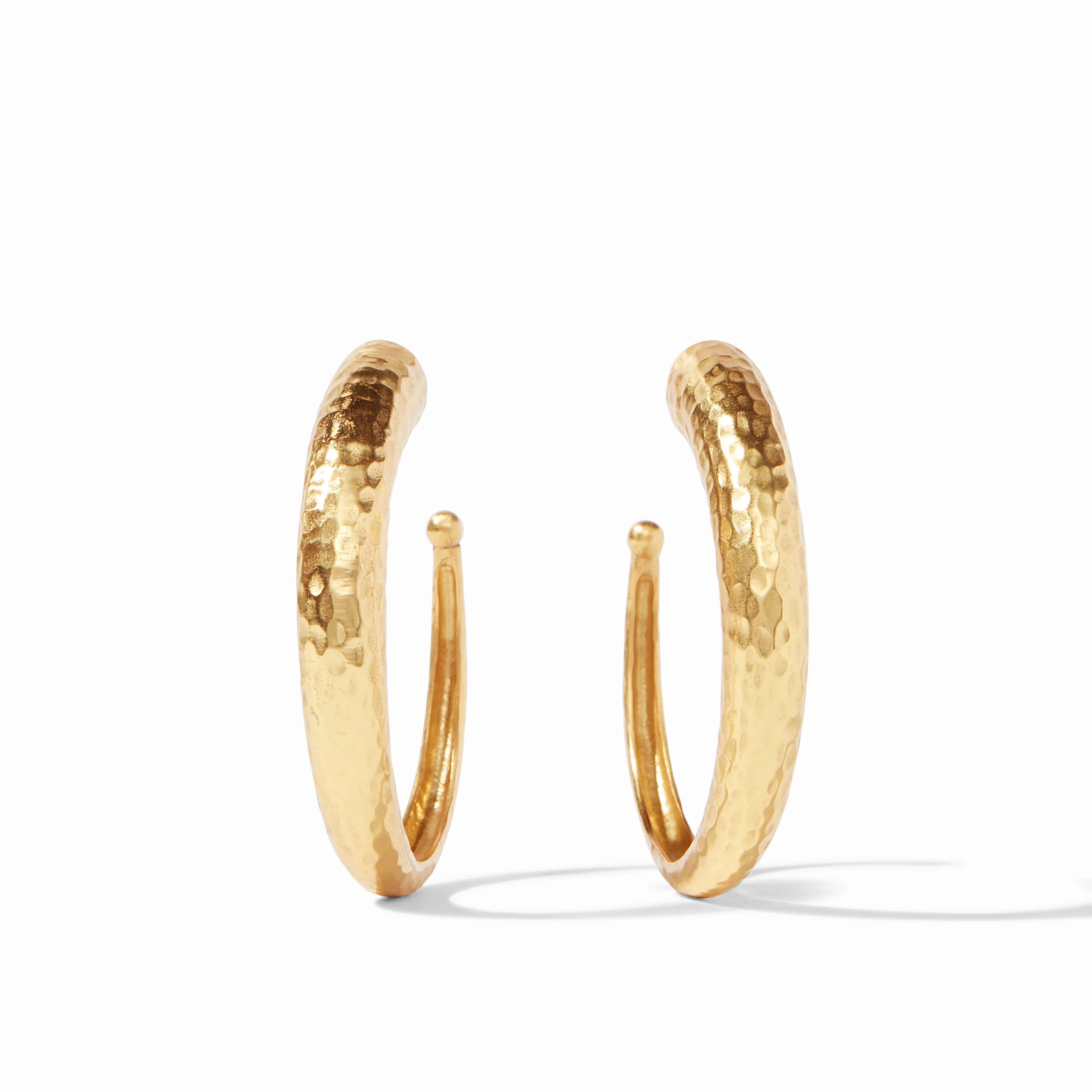 Pair of 24K gold plated hammered hoop earrings on a white background.
