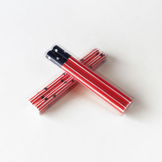 Two Star Spangled taper candles in a clear PVC box with red, white, and blue striped pattern.