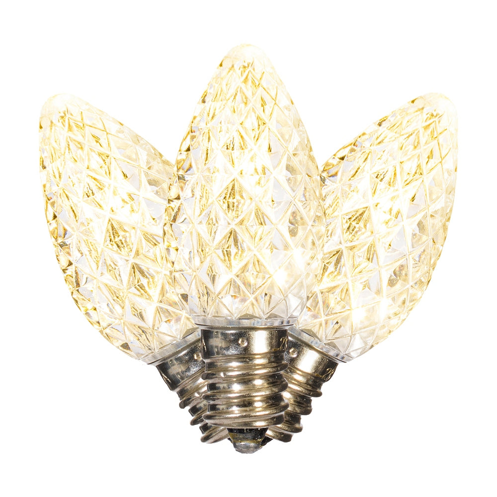 Three faceted warm white C7 LED Christmas light bulbs with a diamond-patterned glass finish.