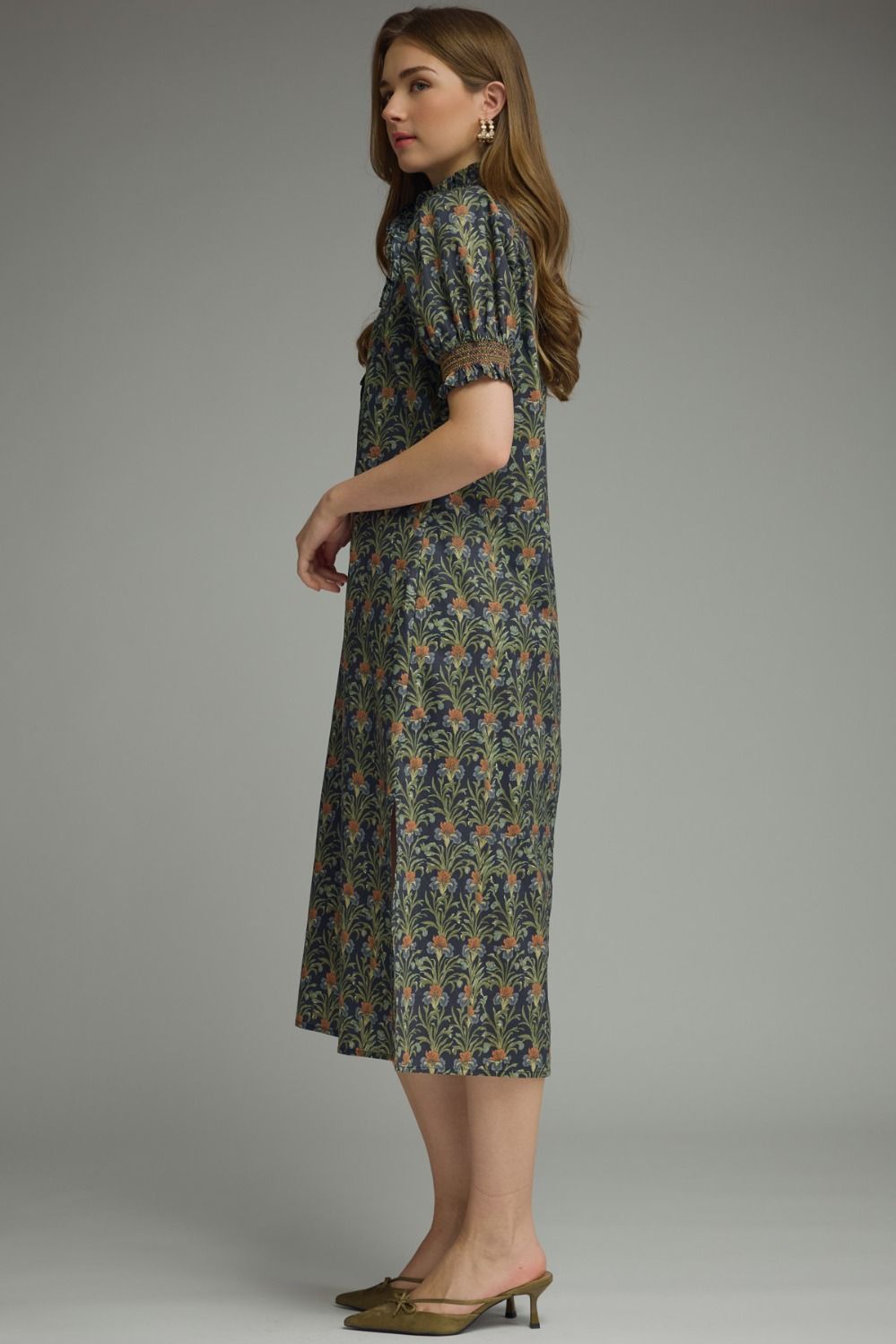 Side view of a woman wearing a Mary floral print midi dress with short puff sleeves.
