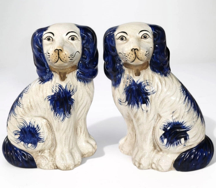 Set of two Staffordshire terrier figurines in black glazed ceramic with white accents.