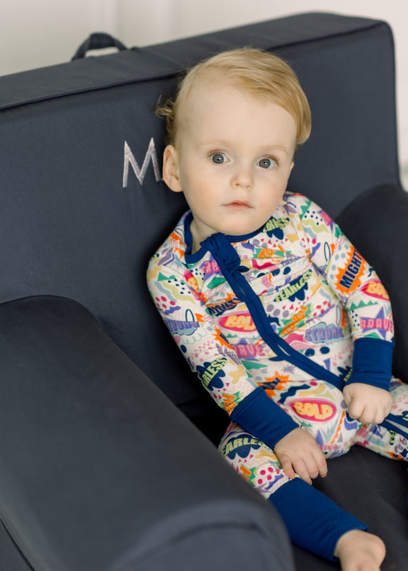 Toddler in The Mighty Mack Boy Zippy, a bamboo viscose pajama with colorful comic-style graphics.