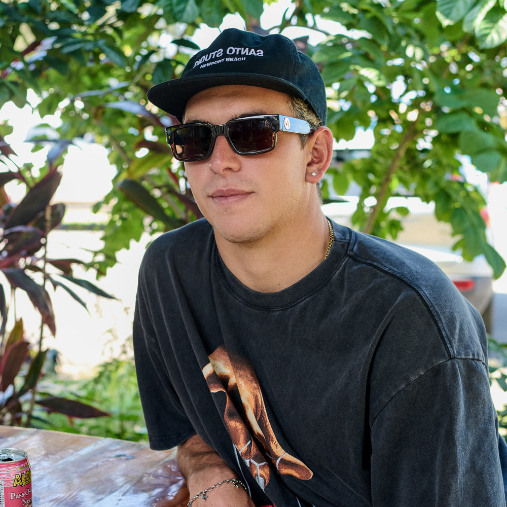 Man wearing Cole Houshmand sunglasses with taupe frames and brown polarized lenses.