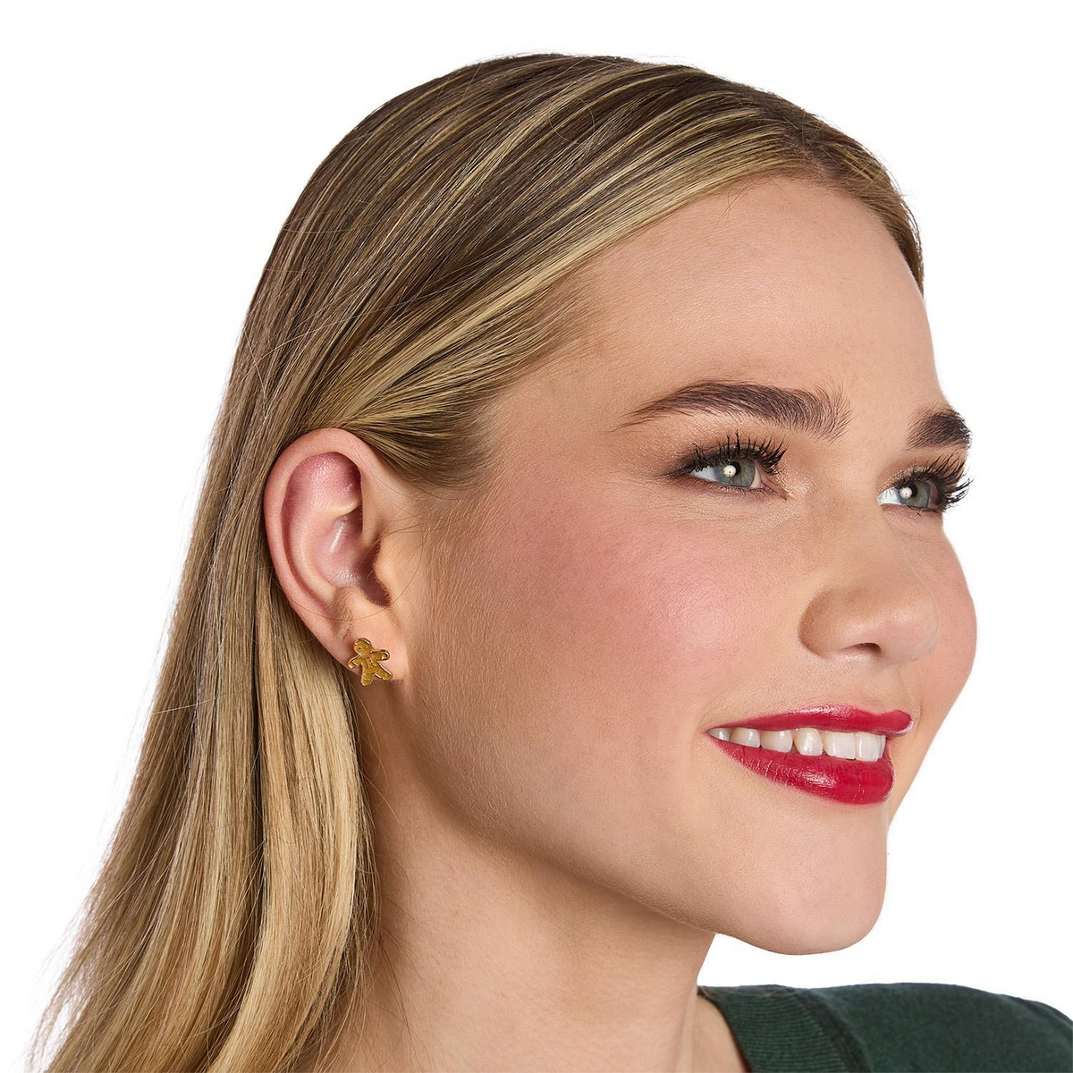 A woman wearing a small gold gingerbread man enamel stud earring.