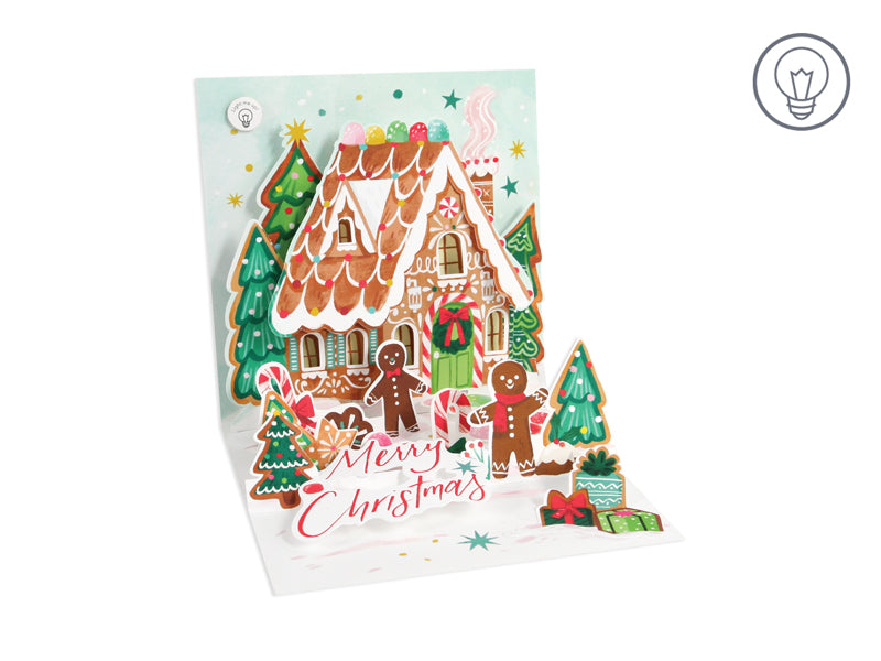 Red foil Christmas card with gingerbread house illustration, two red bows, light effects, and white envelope.