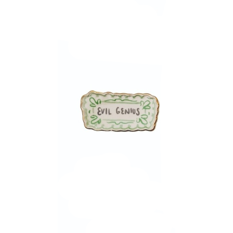 Rectangular stoneware magnet with green scalloped border and 'EVIL GENIUS' text.