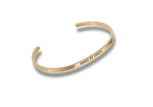 Gold-tone metal cuff bracelet engraved with the words SAVED BY GRACE.