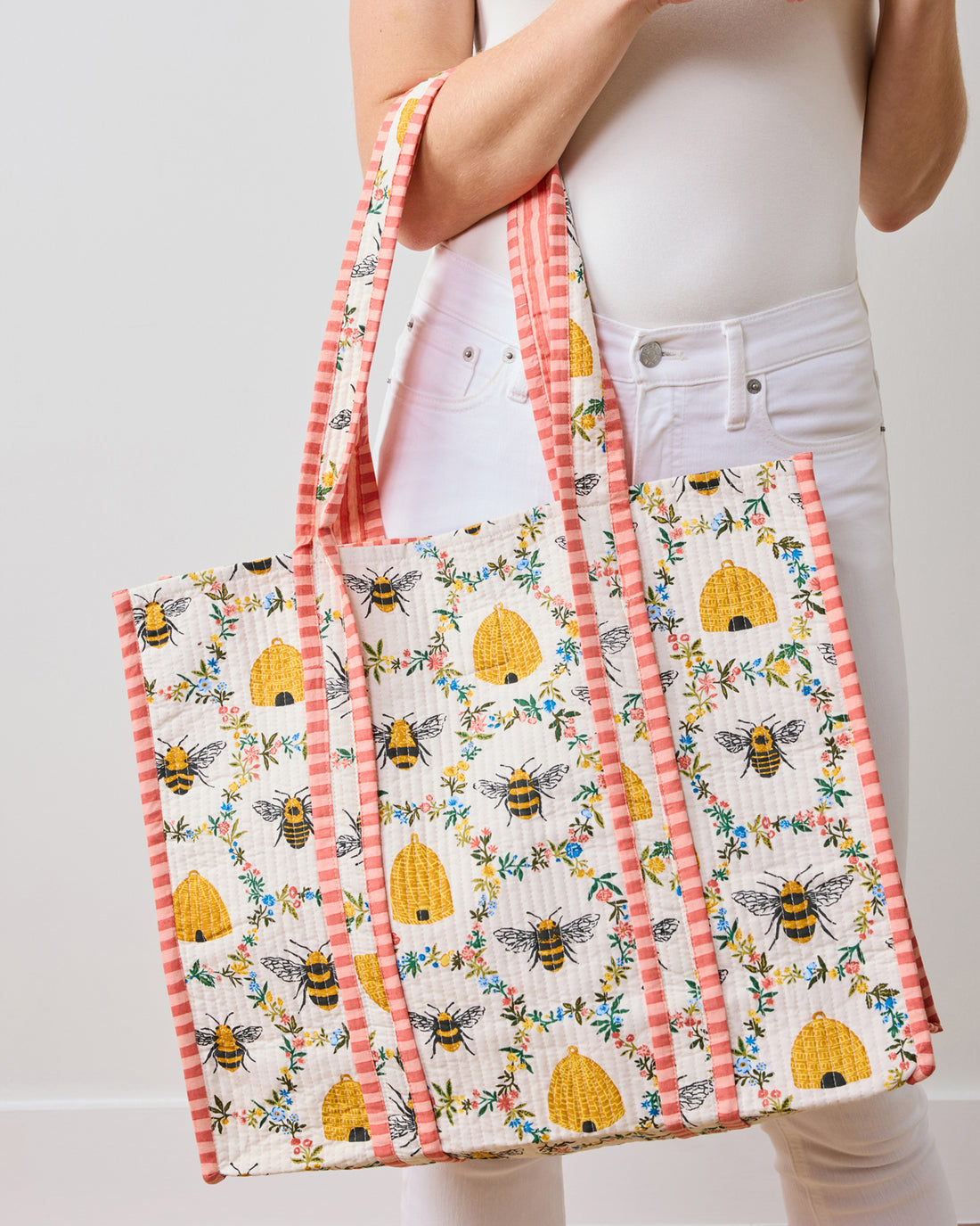 The Traveler Tote in Sweet Bee: a quilted organic cotton bag with bee and beehive patterns.