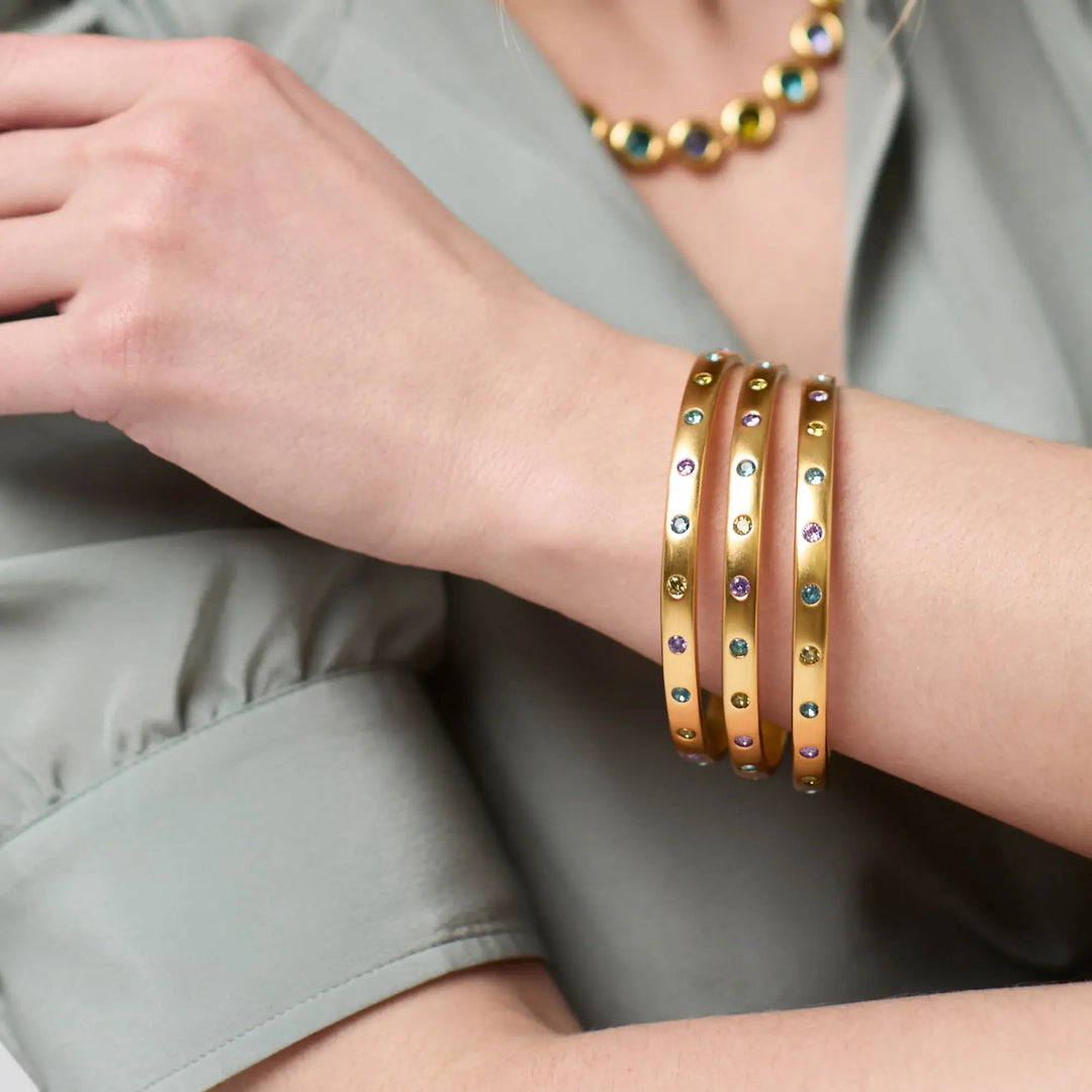 Rainbow bangle with a multicolored band featuring gold plating and cubic zirconia stones.