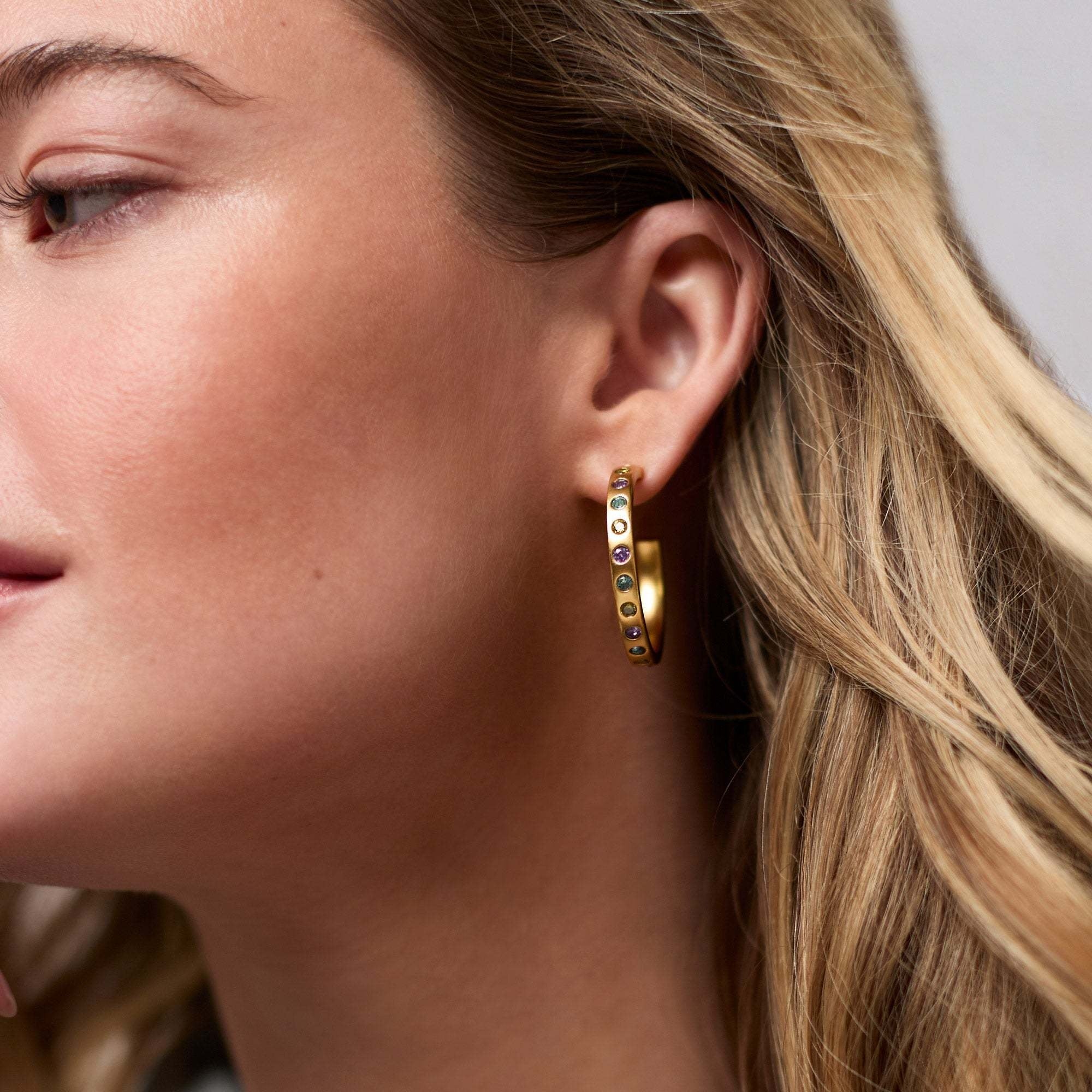 Rainbow hoop earrings with a colorful gradient finish on gold-plated posts.