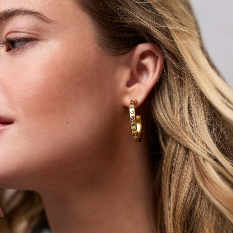 Rainbow hoop earrings with a colorful gradient finish on gold-plated posts.