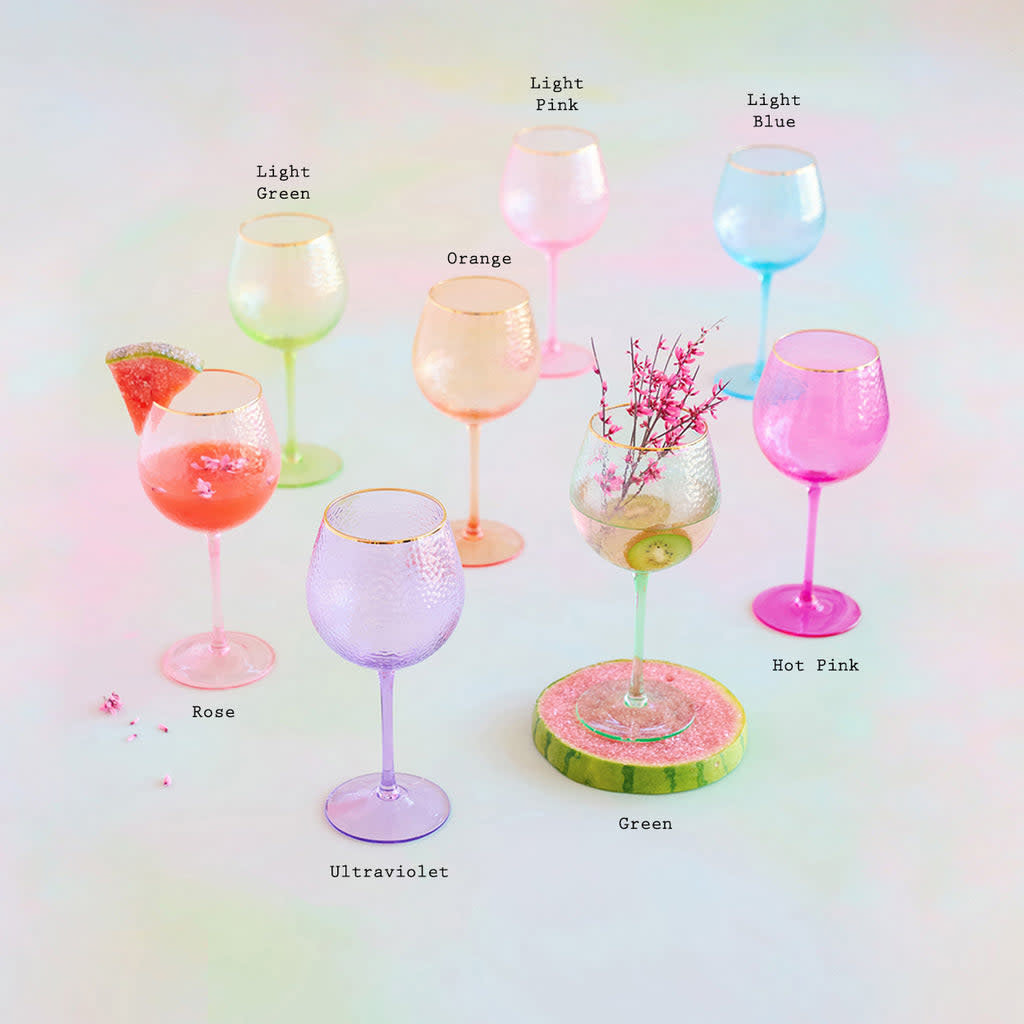 Handblown rainbow wine glass with transparent colored glass, gold accents, and shimmering glitter pattern.