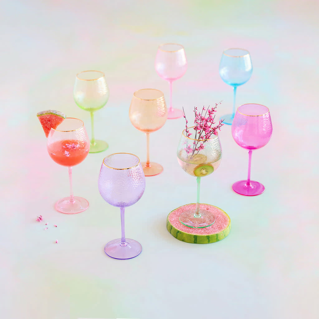 Handblown rainbow wine glass with transparent colored glass, gold accents, and shimmering glitter pattern.