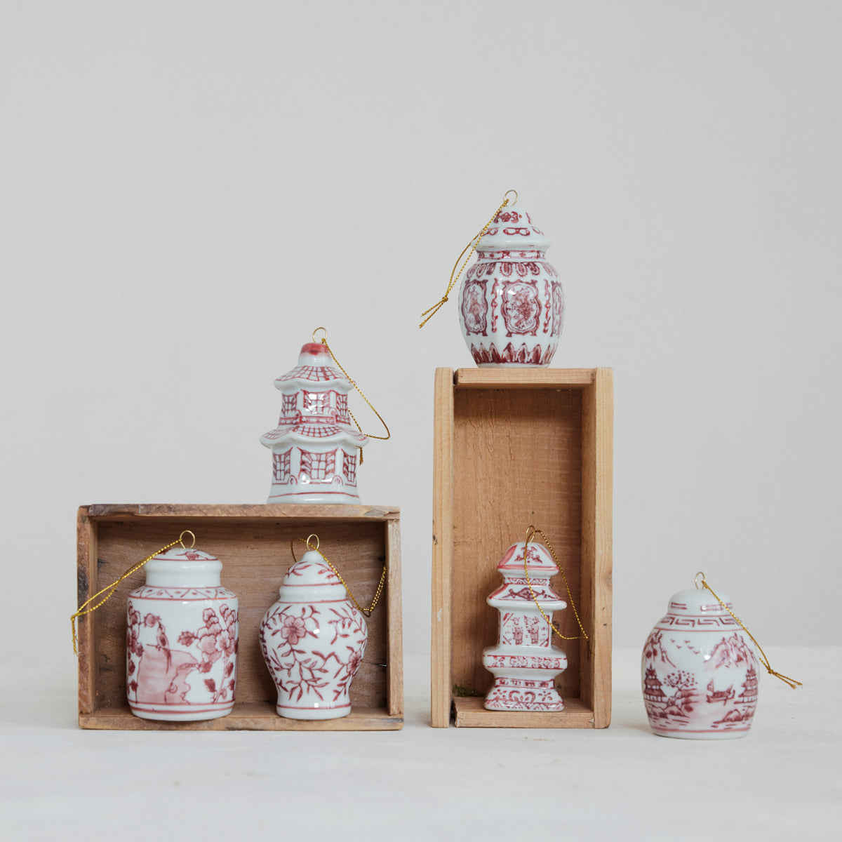 Hand-painted burgundy and white stoneware ginger jar and pagoda ornaments with gold hanging strings.