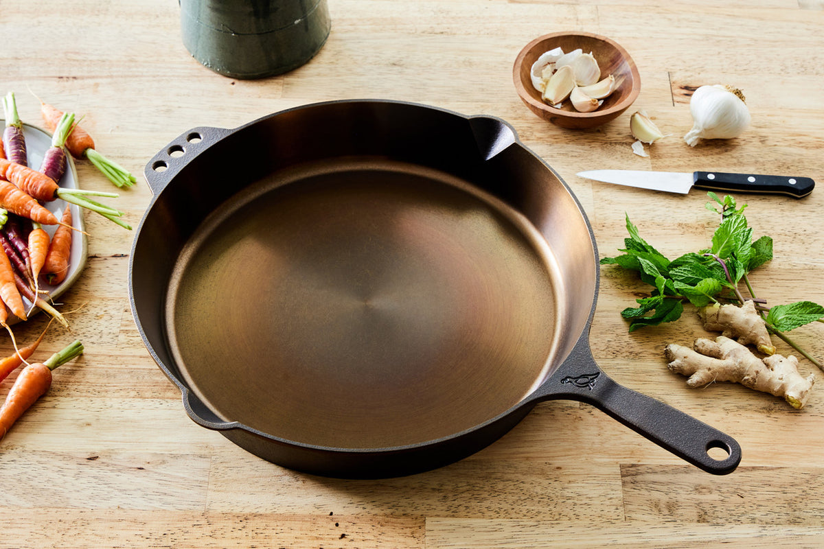 No. 14 Traditional Skillet with a polished finish on a wooden table with fresh ingredients.