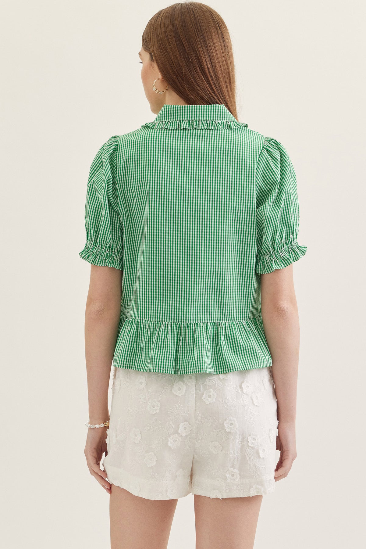 Back view of a woman wearing a green gingham Katie Collared Blouse with short puff sleeves.