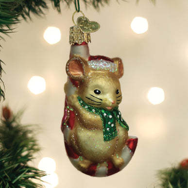 A glass Christmas Mouse ornament wearing a green scarf and Santa hat, sitting on a candy cane.