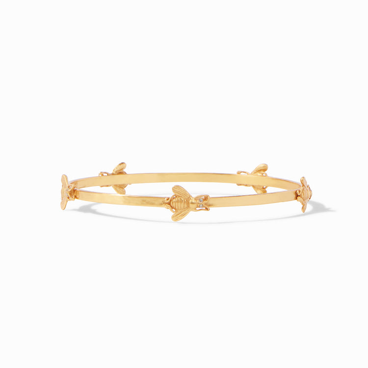 Gold bangle bracelet featuring four small bee charms evenly spaced around the band.