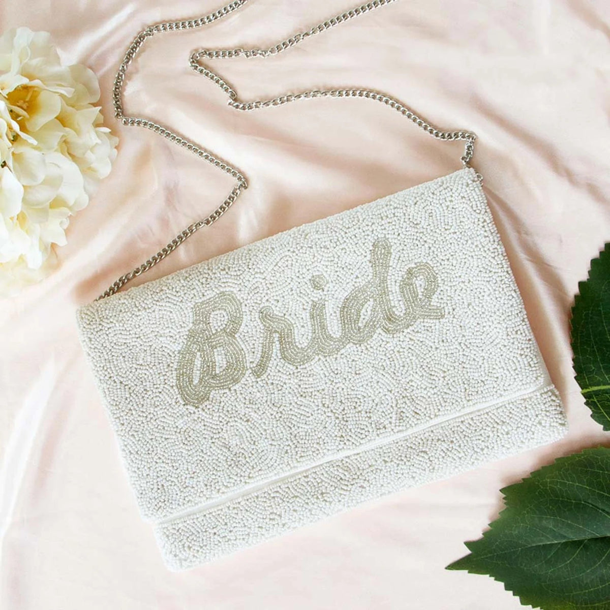 Silver chain clutch purse with magnetic snap closure in durable canvas material.