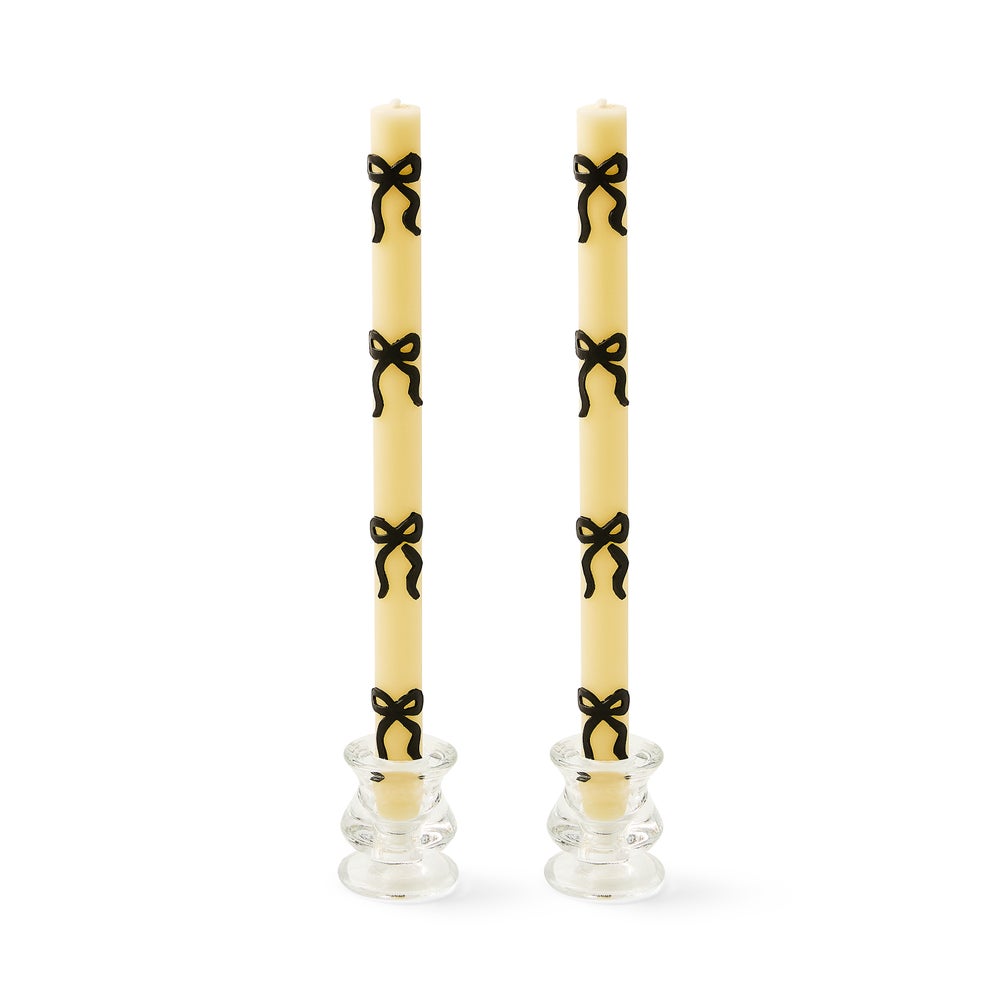 Set of two black dinner candles with bow accents made from a beeswax blend.