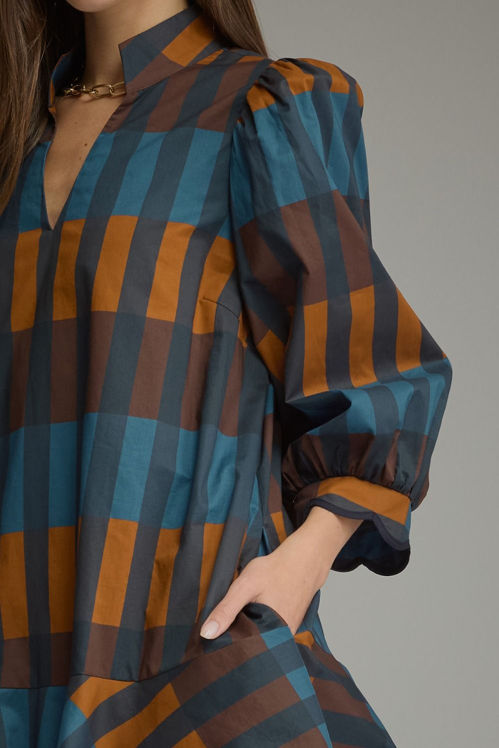 Close-up of the Harper Plaid Mini Dress with a split neck and 3/4 balloon sleeves in blue and brown.