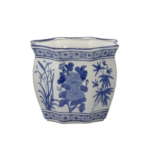 White and blue ceramic hex-shaped chinoiserie planter pot with hand-painted floral designs.